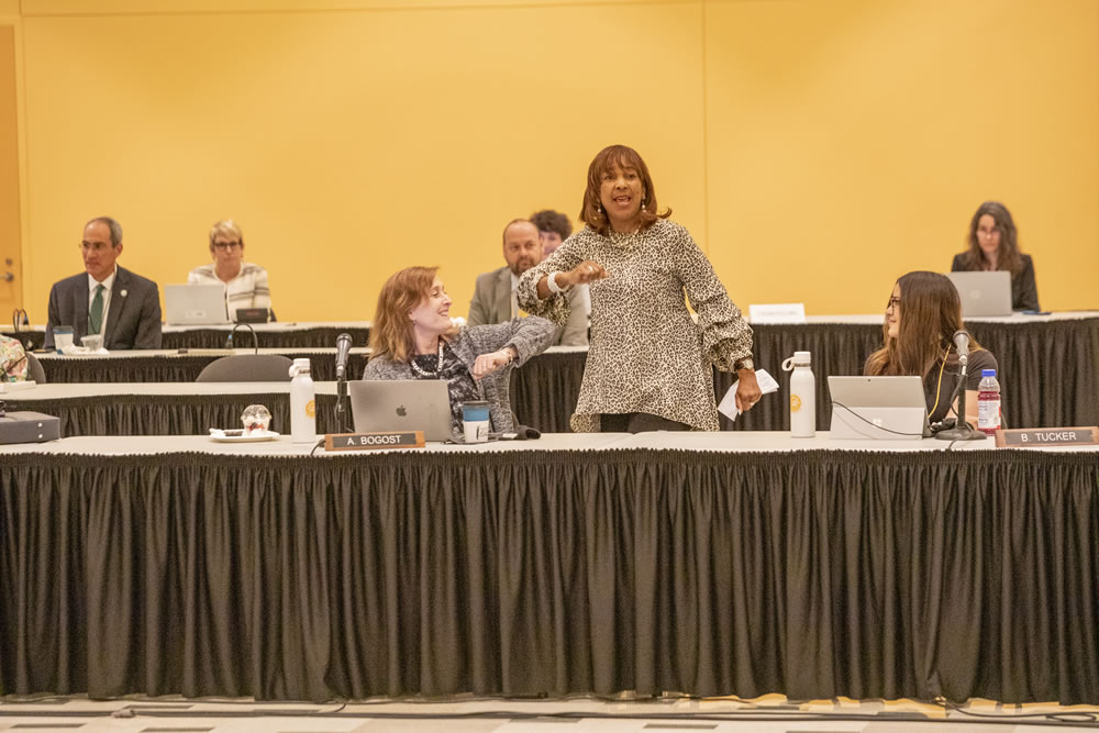 Photo of Regent Amy Bogost and Regent Eve Hall bumping elbows